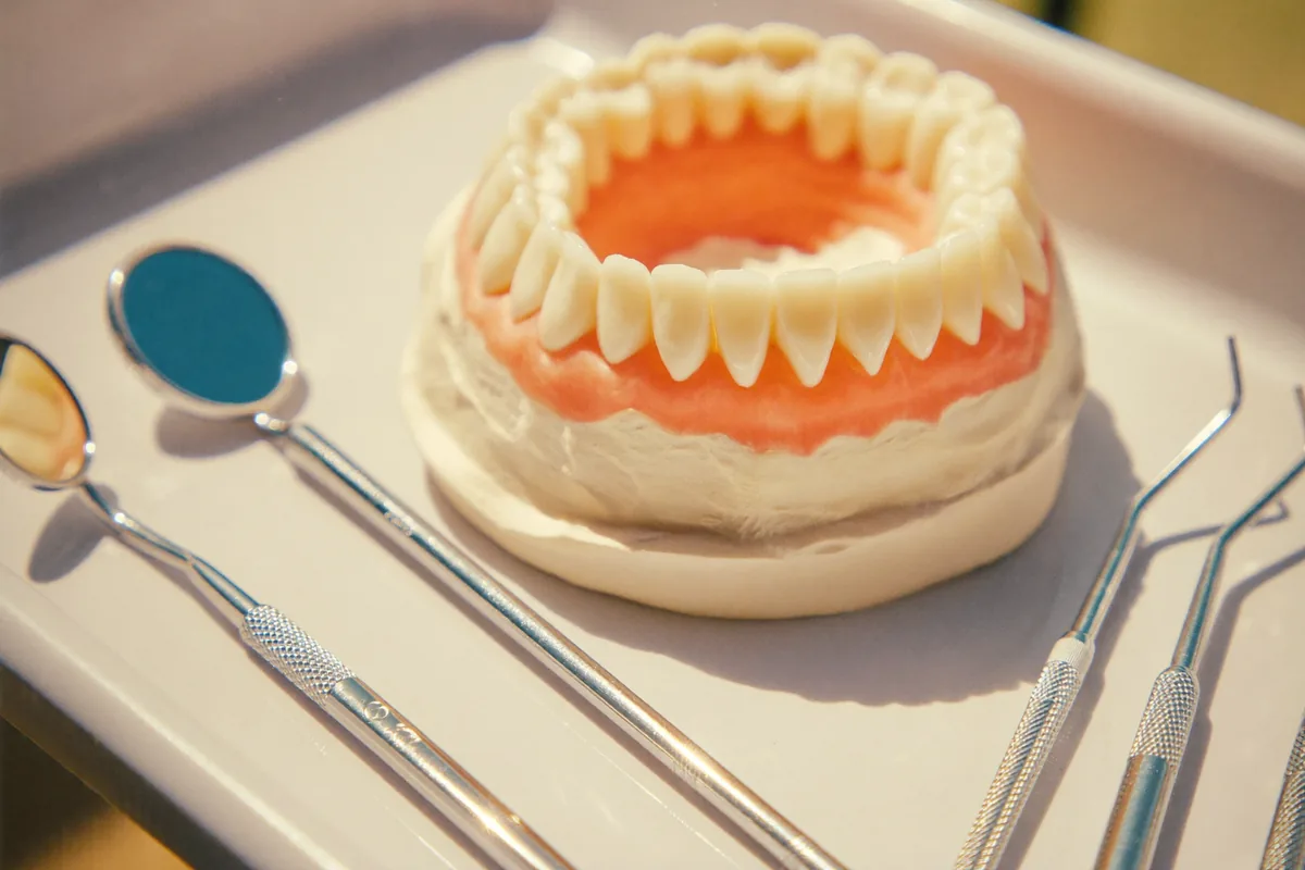 Dental instruments and a plaster model of teeth on a light tray